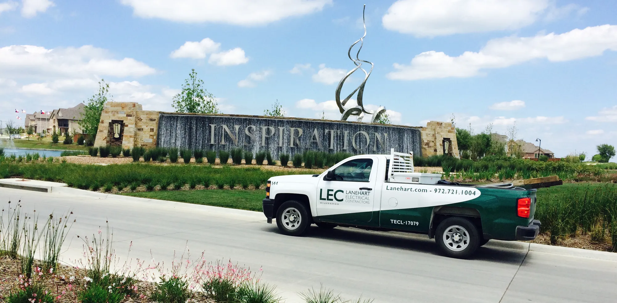Lanehart Electrical Contractors work truck parked at the entrance of a new home community in Texas